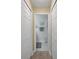 Hallway view of a white tiled bathroom with white cabinets and neutral paint at 3018 Andover Ct, Mount Dora, FL 32757