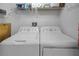 Laundry room with a white washer and dryer and wire shelving at 3018 Andover Ct, Mount Dora, FL 32757