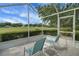 Screened-in patio with outdoor seating and views of the manicured green lawn and trees at 3018 Andover Ct, Mount Dora, FL 32757