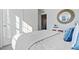 Bright bedroom featuring a decorative round mirror, white bedding, and an open doorway at 3121 Partington Blvd, Davenport, FL 33837