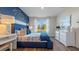Comfortable main bedroom with a large window, a blue accent wall, and modern furnishings at 3121 Partington Blvd, Davenport, FL 33837