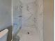 Bathroom featuring a stand-up shower with white marble-style tiling and updated fixtures at 3220 Mahalia Pl, Orlando, FL 32805