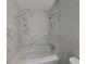 Bathroom featuring a bathtub with white marble-style tiling and updated fixtures at 3220 Mahalia Pl, Orlando, FL 32805