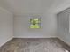 Neutral bedroom with a large window offering backyard views and tile floors at 3220 Mahalia Pl, Orlando, FL 32805
