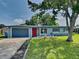 Charming single-story home featuring a vibrant red front door and well-maintained landscaping at 3220 Mahalia Pl, Orlando, FL 32805