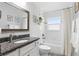 Bright bathroom featuring granite countertop vanity with chrome faucet and tiled shower with curtain at 368 E Chelsea St, Deland, FL 32724