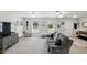 Bright living room features wood floors, two windows, ceiling fans, and gray sofa at 368 E Chelsea St, Deland, FL 32724