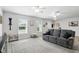 Bright living room features wood floors, two windows, ceiling fans, and gray sofa at 368 E Chelsea St, Deland, FL 32724