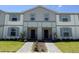 Charming townhome featuring a neutral color scheme, welcoming entrance, and well-maintained landscaping at 3806 Lana Ave, Davenport, FL 33897