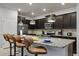 Close-up of the kitchen island featuring granite countertops, stainless steel appliances, and bar seating at 3806 Lana Ave, Davenport, FL 33897