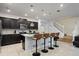 Modern kitchen with granite countertops, stainless steel appliances, island with bar seating, and staircase at 3806 Lana Ave, Davenport, FL 33897