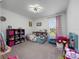 Cozy bedroom with carpet flooring, toys, and a window providing natural light at 4743 Sw 114Th Pl, Ocala, FL 34476