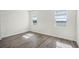 Bedroom featuring wood-look floors and two large windows showing lake views at 5227 Ligonberry St, Lakeland, FL 33811