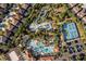 Aerial view showcases a resort-style community pool, tennis courts, and lush greenery at 5270 Wildwood Way, Davenport, FL 33837