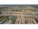 Aerial view of neighborhood with swimming pool, tennis court, and rows of houses with red roofs at 5270 Wildwood Way, Davenport, FL 33837