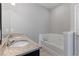 Bathroom featuring double sinks with granite countertop, a soaking tub, and modern fixtures at 5270 Wildwood Way, Davenport, FL 33837