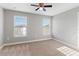 Well lit bedroom with plush carpeting, ceiling fan, and two windows at 5270 Wildwood Way, Davenport, FL 33837