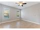 Spacious bedroom featuring tile flooring, neutral walls, ceiling fan, and multiple windows for natural light at 5270 Wildwood Way, Davenport, FL 33837