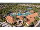 A close aerial view of the community pool and pool house surrounded by palm trees and blue umbrellas at 5270 Wildwood Way, Davenport, FL 33837