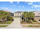Charming home featuring a well-manicured lawn, mature palm trees, and a welcoming entryway at 5270 Wildwood Way, Davenport, FL 33837