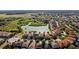 An aerial view of houses with a pond behind them, with trees separating them from the grassland at 5270 Wildwood Way, Davenport, FL 33837