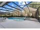 Relaxing screened pool with a jacuzzi and ample lounge seating surrounded by lush landscaping at 5270 Wildwood Way, Davenport, FL 33837