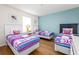 Bright bedroom with three twin beds, decorative butterfly pillows, and colorful linens at 550 Las Fuentes Dr, Kissimmee, FL 34746