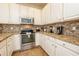 Kitchen featuring stainless steel appliances, stylish backsplash, and granite countertops at 550 Las Fuentes Dr, Kissimmee, FL 34746