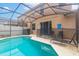 Backyard view of the screened-in pool with lounge chairs and secure pool fencing at 550 Las Fuentes Dr, Kissimmee, FL 34746