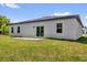 Back exterior featuring sliding glass doors, leading to a patio, and a grassy area at 5835 Sw 154 Lane Rd, Ocala, FL 34473