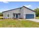 Charming single-story home with a blue front door and attached two-car garage at 5835 Sw 154 Lane Rd, Ocala, FL 34473