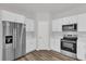 Bright kitchen features stainless steel appliances, white cabinetry, quartz countertops and wood-look flooring at 5835 Sw 154 Lane Rd, Ocala, FL 34473