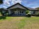 Home's backyard with a covered patio, outdoor furniture, and lush landscaping at 603 Sanctuary Golf Pl, Apopka, FL 32712