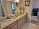 This is a full bathroom with double sinks, a granite countertop, and decorative vases at 603 Sanctuary Golf Pl, Apopka, FL 32712