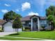 Beautiful single-story home with a well-manicured lawn, grey paint and large garage at 603 Sanctuary Golf Pl, Apopka, FL 32712