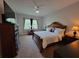 This is a traditionally decorated main bedroom with a large bed, ceiling fan, and a window seating area at 603 Sanctuary Golf Pl, Apopka, FL 32712