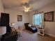 This home office features a comfortable chaise lounge, desk, ceiling fan, and natural light from the window at 603 Sanctuary Golf Pl, Apopka, FL 32712