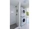 Modern bathroom with a stylish tiled shower and convenient stacked washer and dryer at 6124 Bear Lake Ter, Apopka, FL 32703