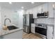 Stylish kitchen featuring granite counters, white cabinets, and stainless appliances at 6124 Bear Lake Ter, Apopka, FL 32703