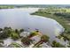 Aerial view of a lakeside property featuring a well-manicured lawn, private dock, and stunning lake views at 616 Grand Cypress Pt, Sanford, FL 32771