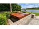 Backyard featuring a hot tub encased in brick, and views of the lake and boat dock at 616 Grand Cypress Pt, Sanford, FL 32771
