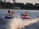 Children enjoy fun lake activities like tubing, creating memorable summer adventures at 616 Grand Cypress Pt, Sanford, FL 32771
