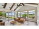 Bright living room featuring vaulted ceilings with wood beams, expansive windows, and stunning lake views at 616 Grand Cypress Pt, Sanford, FL 32771