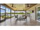Spacious, tiled outdoor patio with ceiling fans, lounge seating, and serene lake views at 616 Grand Cypress Pt, Sanford, FL 32771