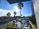 View of parking lot with tall palm trees and an office building with blue sky in the background at 6165 Carrier Dr # 2308, Orlando, FL 32819