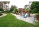 Community playground featuring a slide, climbing structure, and lush green grass at 6165 Carrier Dr # 2308, Orlando, FL 32819