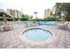 Outdoor pool and jacuzzi area surrounded by lounge chairs and tables for relaxation at 6165 Carrier Dr # 2308, Orlando, FL 32819