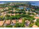 Drone shot of a house near a lake with a screened in pool in a residential area at 6550 Crestmont Glen Ln, Windermere, FL 34786