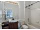 Clean bathroom features a tub-shower combo, white tile, and a charming vanity at 6550 Crestmont Glen Ln, Windermere, FL 34786