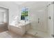 Bathroom featuring a soaking tub under a window, and a glass enclosed shower at 6550 Crestmont Glen Ln, Windermere, FL 34786